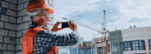 Byggearbejder tager et foto med en smartphone